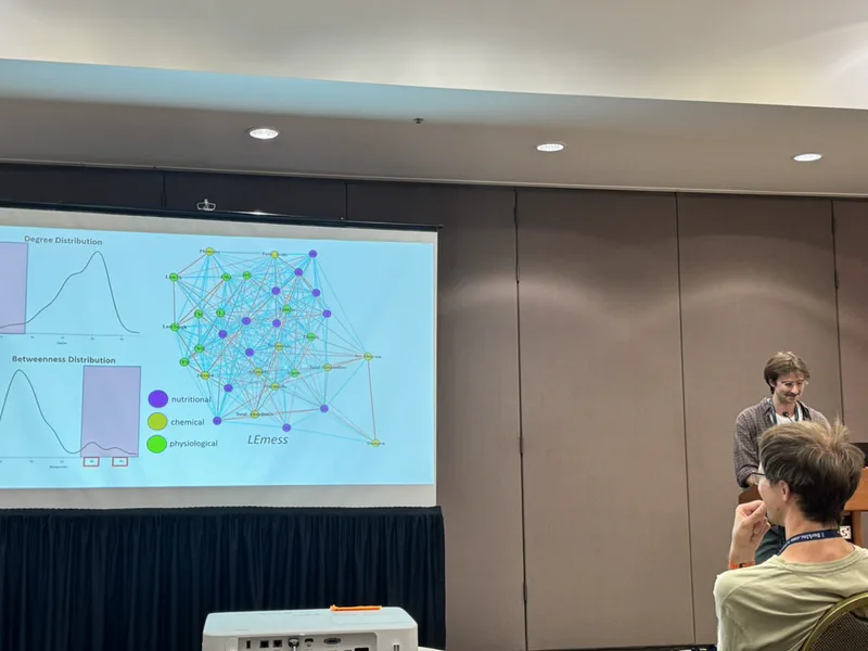A lab member presenting a network diagram linking nutritional, chemical, and physiological traits.