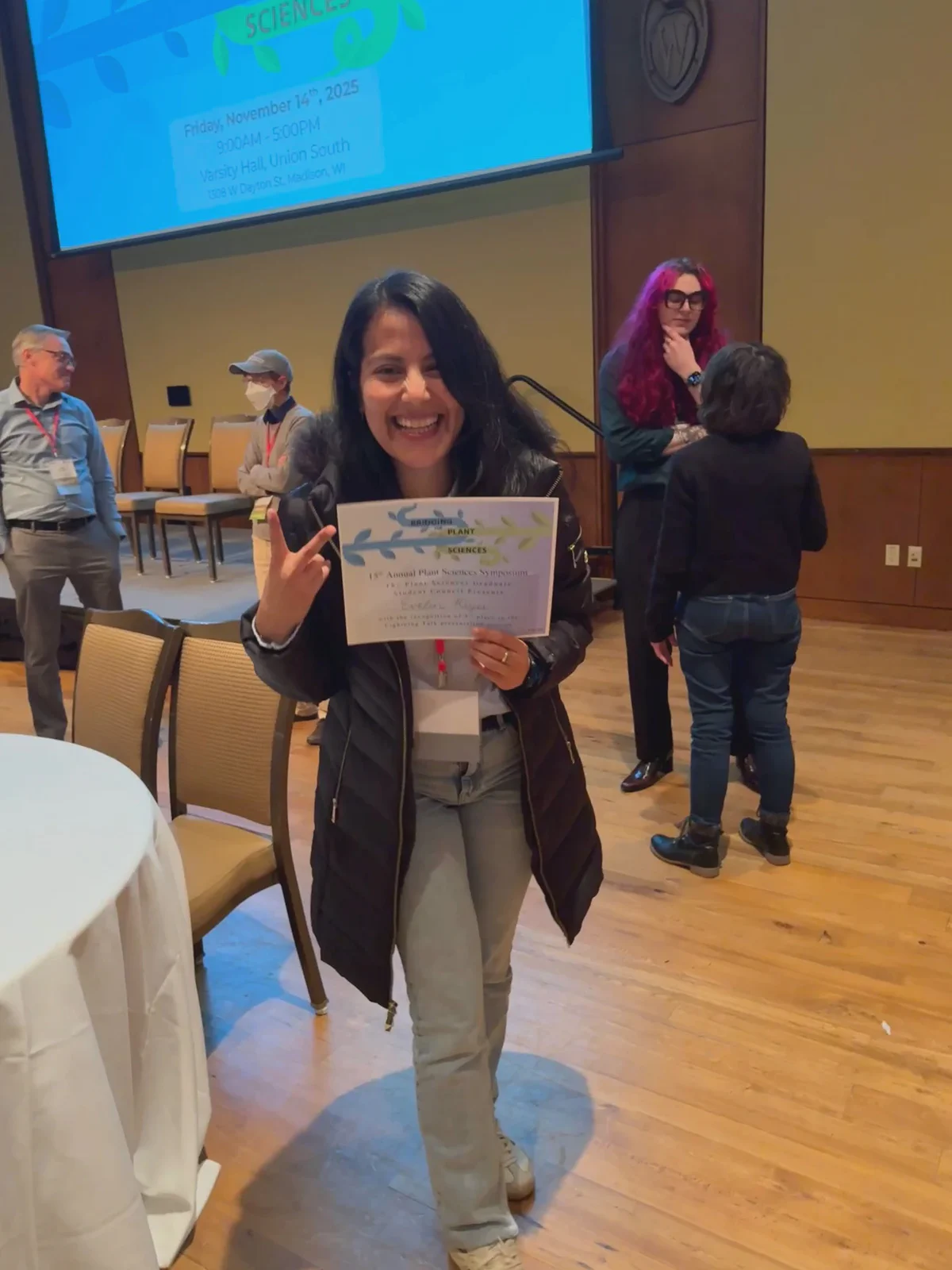 Evelin Reyes holding her award certificate at the Plant Sciences Symposium.