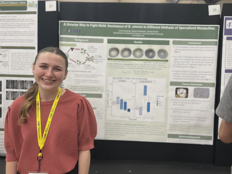 A student standing in front of a poster with fungal culture images.